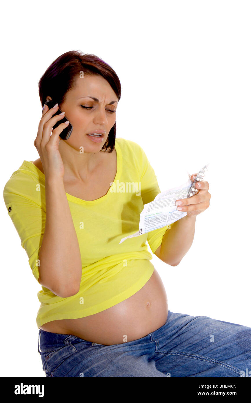 Femme enceinte avec un cellulaire et mode d'emploi Banque D'Images