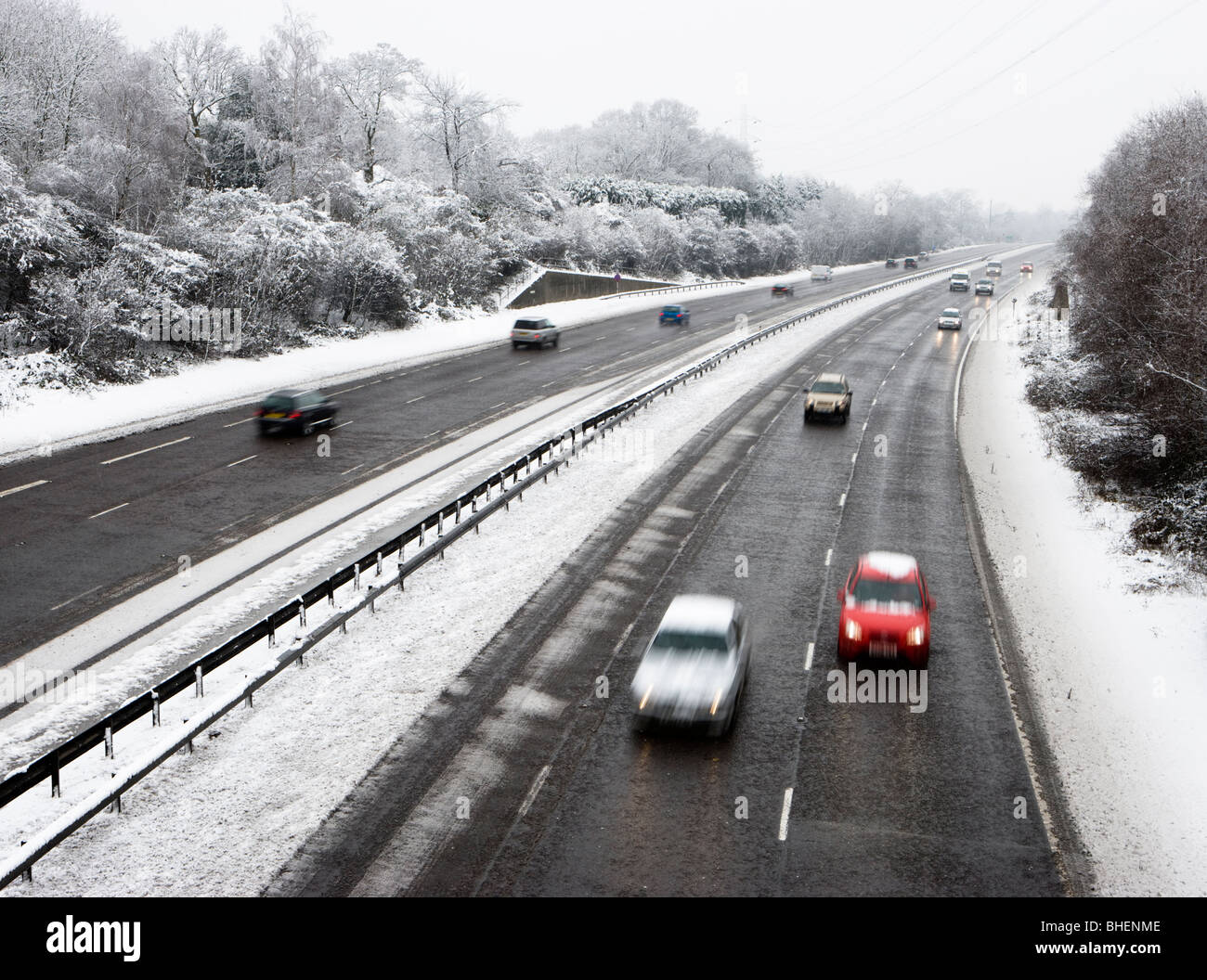 La circulation sur deux voies dans la neige. Deux voies effacée par saleuses. Surrey, UK Banque D'Images