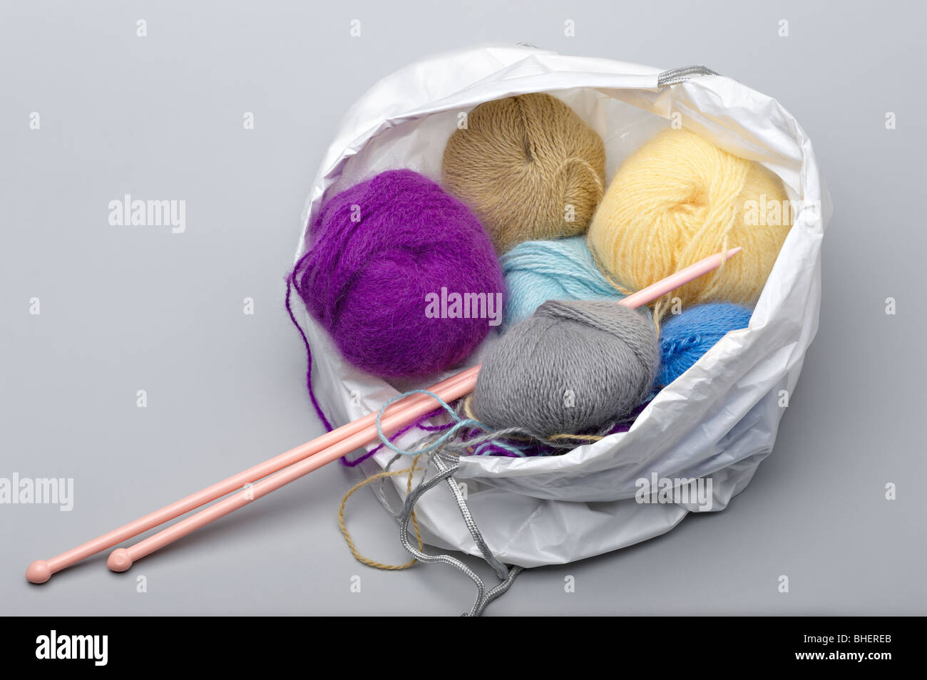 Balles de laine à tricoter Angora colorés et des aiguilles à tricoter dans un sac shopping Banque D'Images