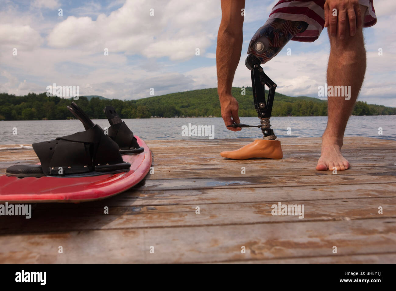 Réglage de l'athlète handicapé sa jambe artificielle sur un quai Banque D'Images