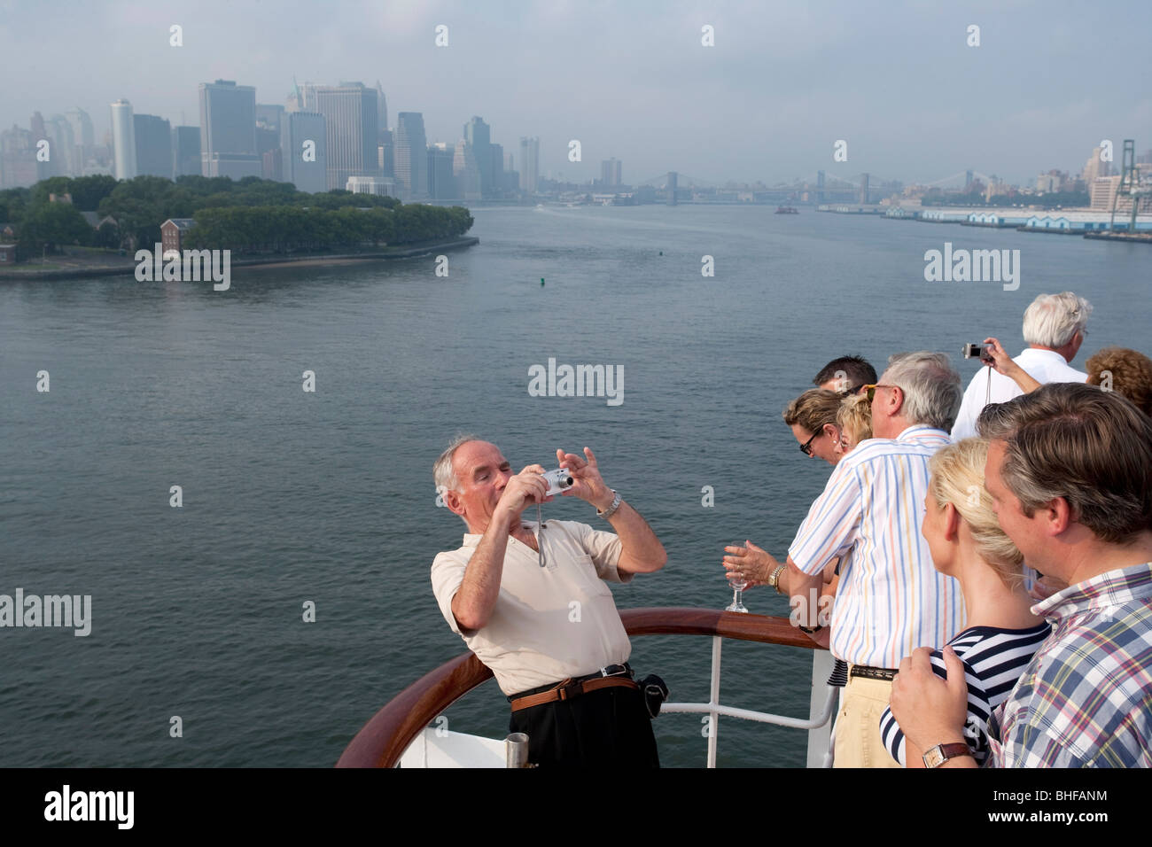 Départ de New York, les passagers à prendre des photos sur le pont arrière, plage arrière, New York City skyline en arrière-plan, Banque D'Images