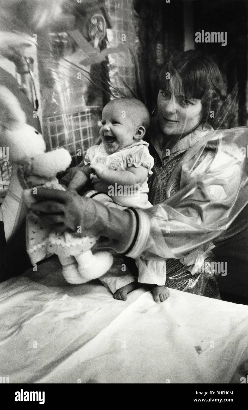 Un Bebe Sans Systeme Immunitaire Dans Une Bulle Sterile Avec Sa Mere Qui Ne Pouvait Tenir Son Grace A L Ecran Avec Des Gants En Caoutchouc Photo Stock Alamy