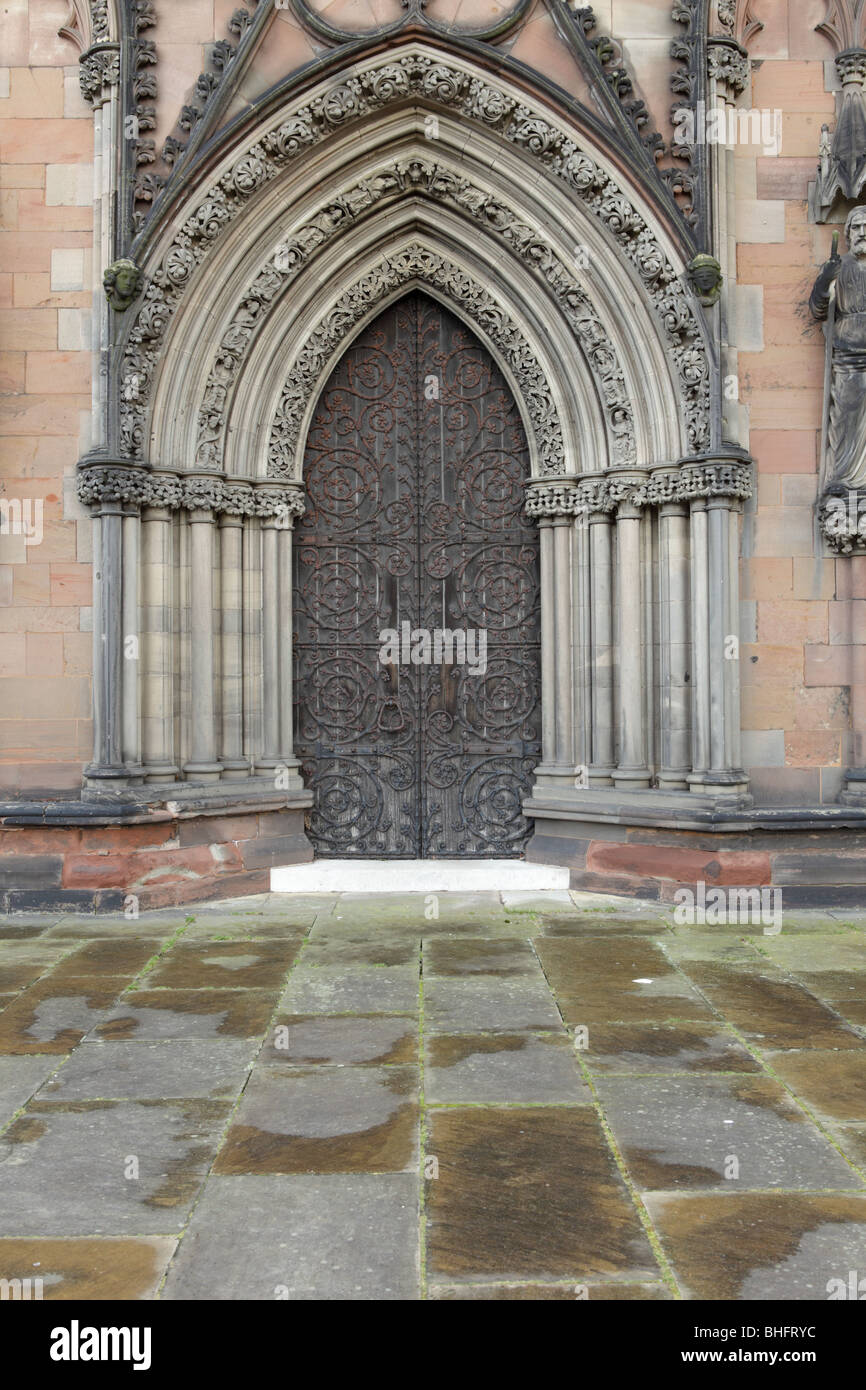 Situé à droite de la grande porte de l'Ouest à la Cathédrale de Lichfield est finement construit cette porte et porte de pierre. Banque D'Images