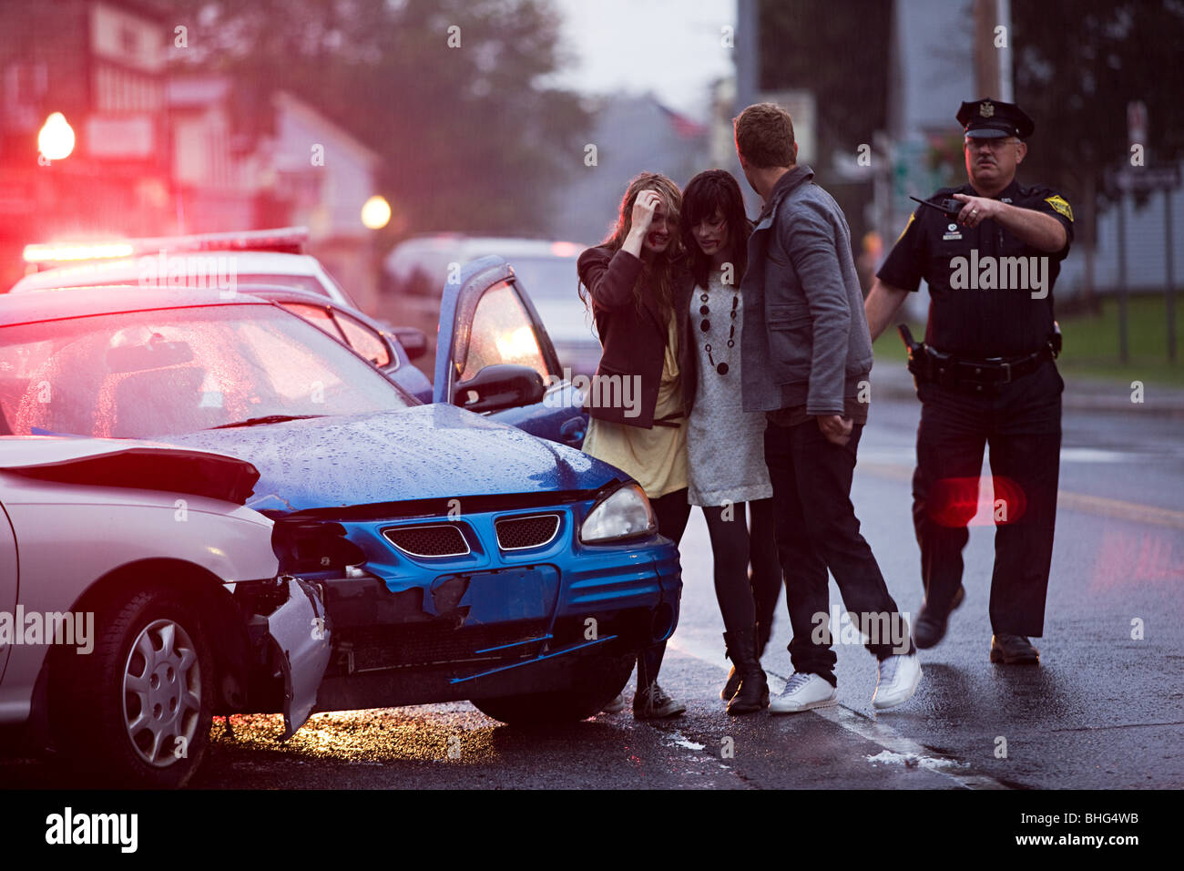 Les jeunes et l'agent de police lors d'accident de voiture Banque D'Images