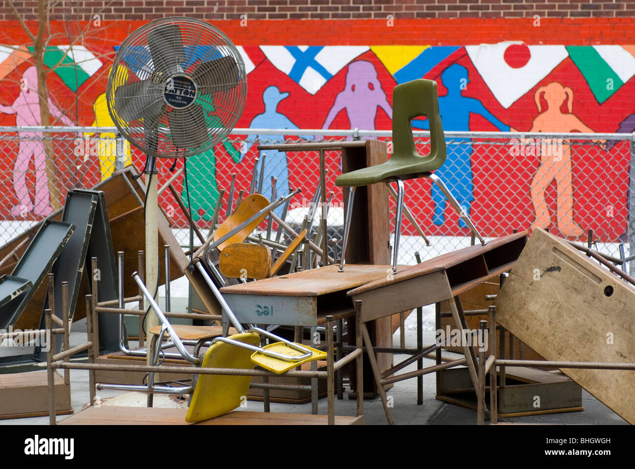 Vieux bureaux, chaises et autres meubles de l'école sont entassés à l'extérieur du PS 33 dans le quartier de Chelsea, New York Banque D'Images