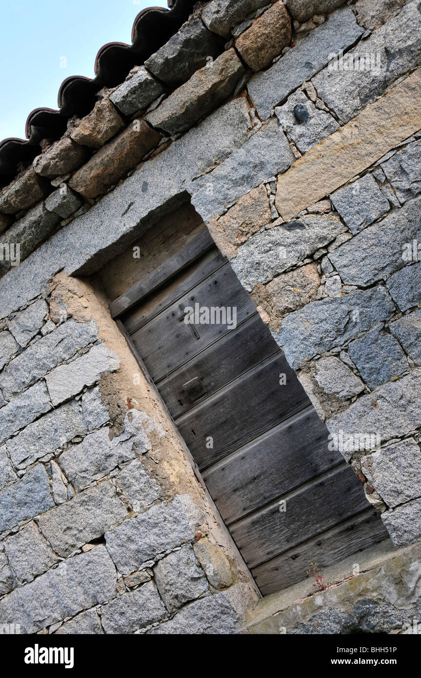 Porte de grange en bois avec crucifix dans un village corse Banque D'Images