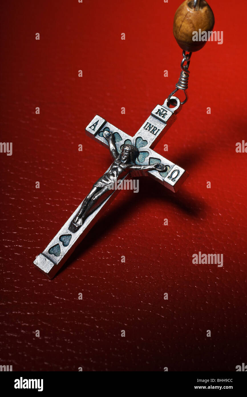 Un crucifix sur fond rouge. Banque D'Images