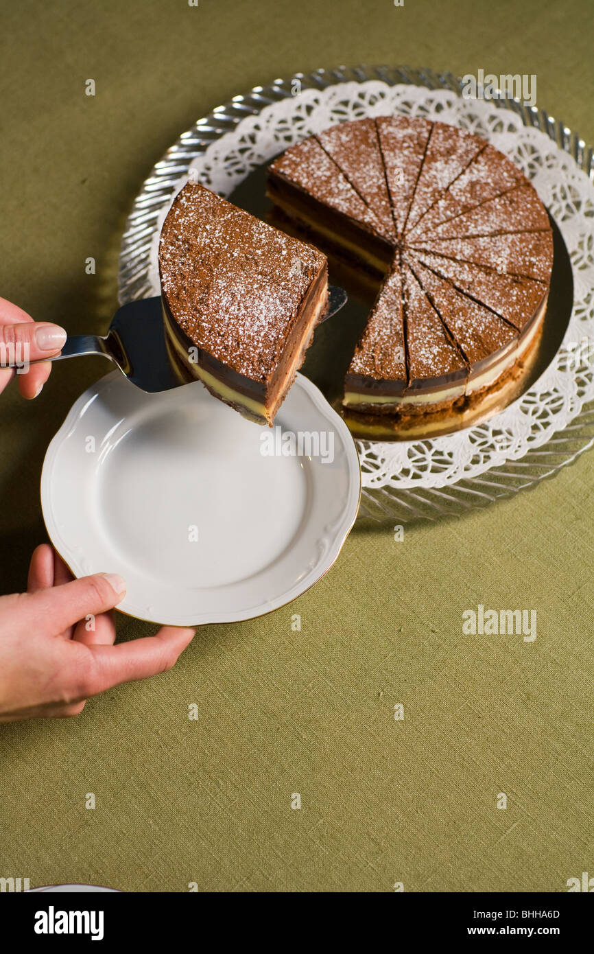 Part de prendre une grande partie d'un gâteau au chocolat. Banque D'Images