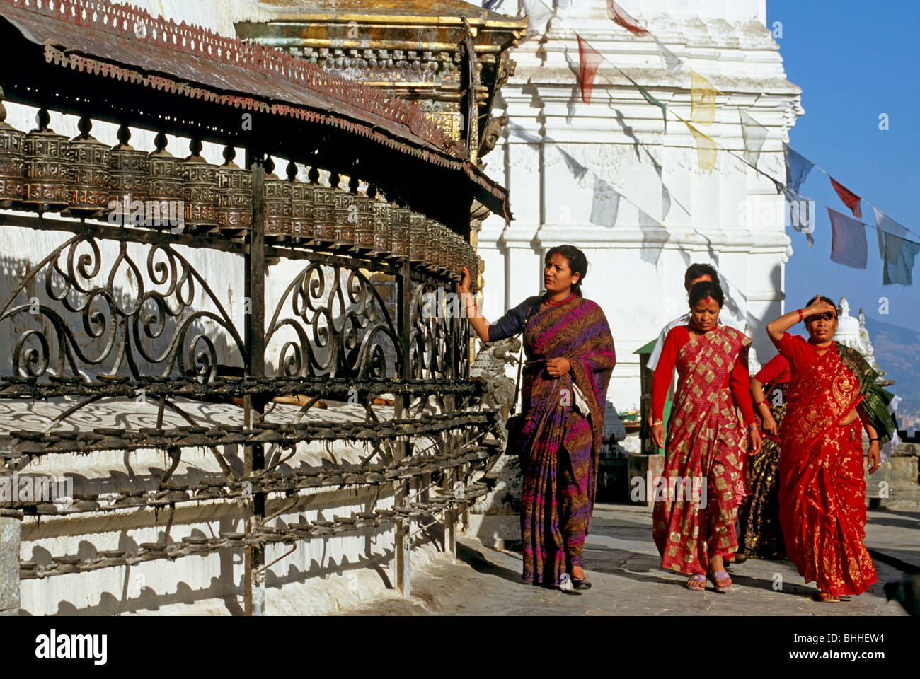 Les femmes népalaises en Saris Spinning roues de prière au Temple de Swayambhunath Kathmandou Népal singe Banque D'Images