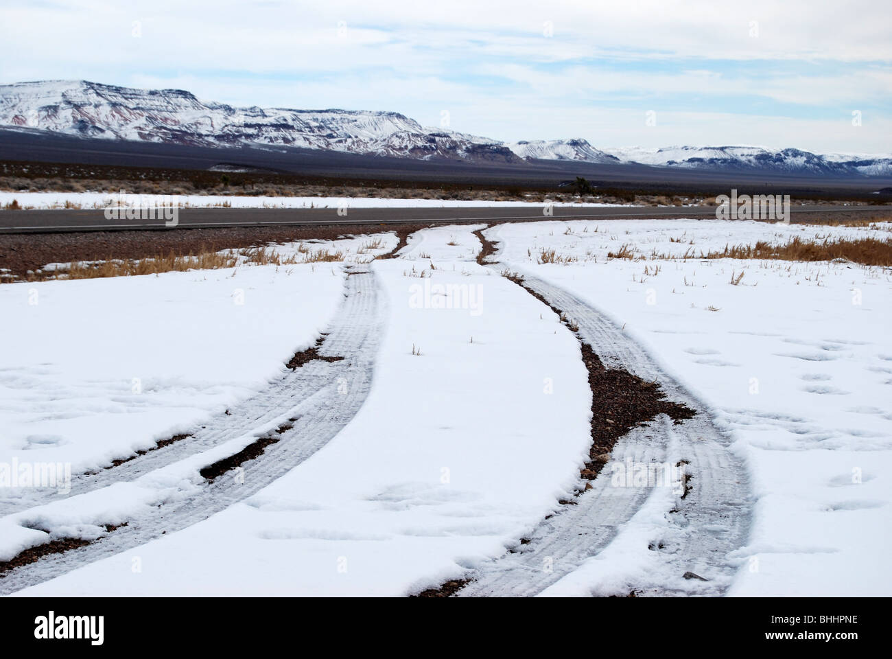 Les traces de pneu neige laissant sur le côté de l'autoroute à deux voies au Nevada Banque D'Images