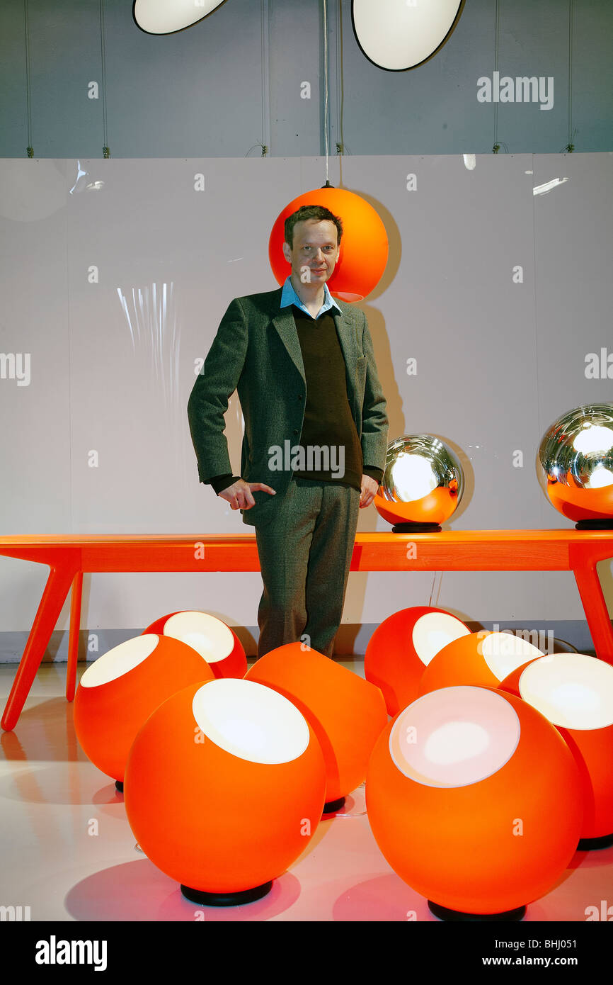 Tom Dixon posant en face de ses lampes au cours de Salone del Mobile 2009, Milano, Italie Banque D'Images