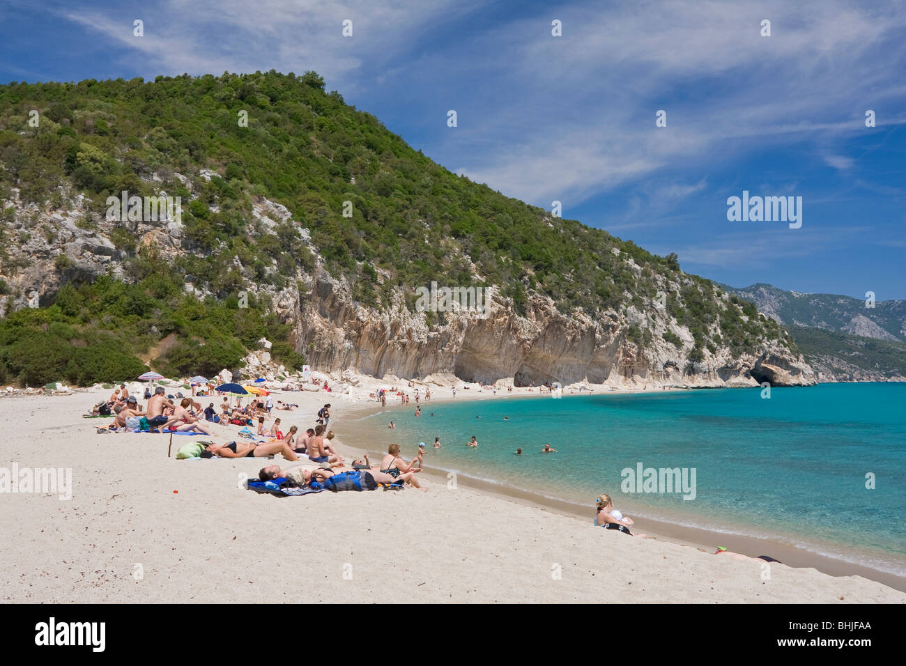 Les gens dans le bain de soleil plage Cala Luna, Sardaigne, île de l'Italie. Eau bleu clair dans la baie de Cala Luna, Mer Méditerranée. Banque D'Images