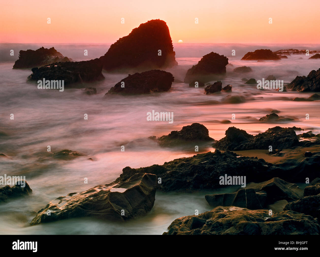 Peinture des vagues de sable et de rochers au coucher du soleil à Woods Cove à Laguna Beach, Californie Banque D'Images