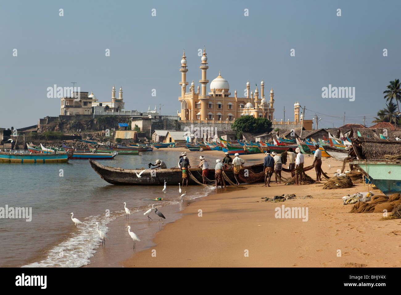 L'Inde, le Kerala, Kovalam, village de pêcheurs Vizhinjam bateaux de pêche sur plage en face d'une mosquée Banque D'Images