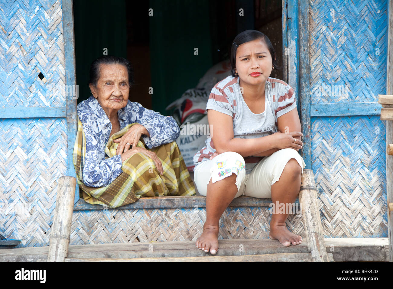 Mère et sa fille devant leur maison dans la région de Sumbawa, en Indonésie Banque D'Images