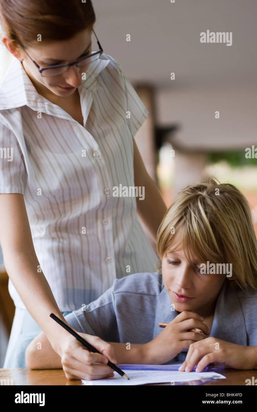 Aider l'enseignant dans la classe d'étudiants de l'école élémentaire Banque D'Images