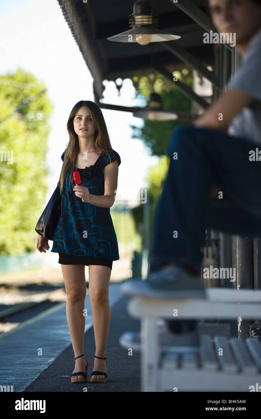 Jeune femme avec ma glace en attente à l'arrêt de bus Banque D'Images