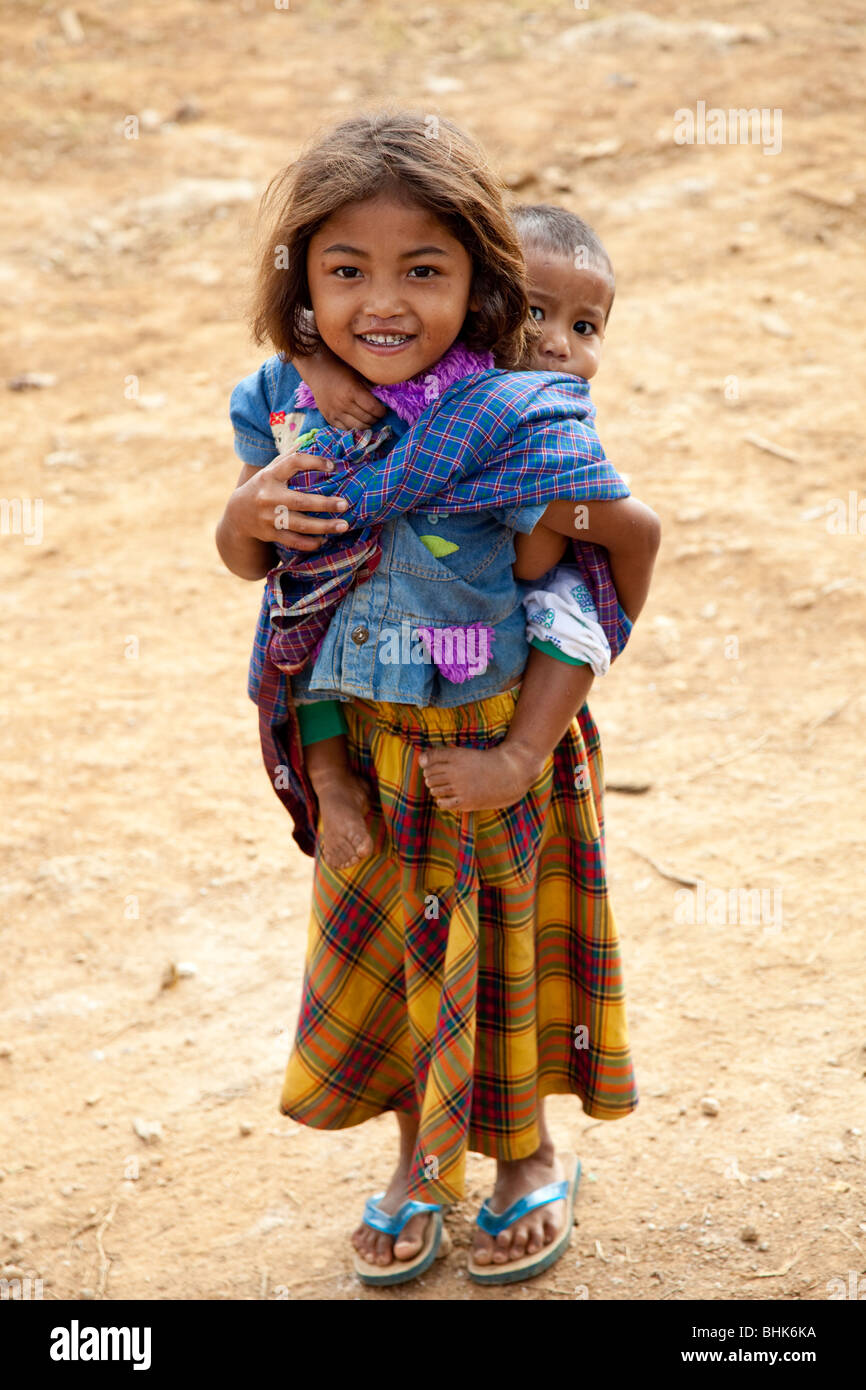 Jeune fille portant son petit frère autour de sur son dos, Ruteng, Flores Banque D'Images