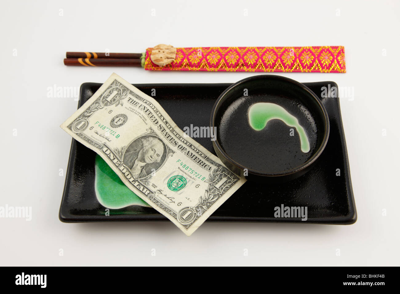 Un dollar des Etats-Unis Bill sur une plaque sushi avec des baguettes Banque D'Images