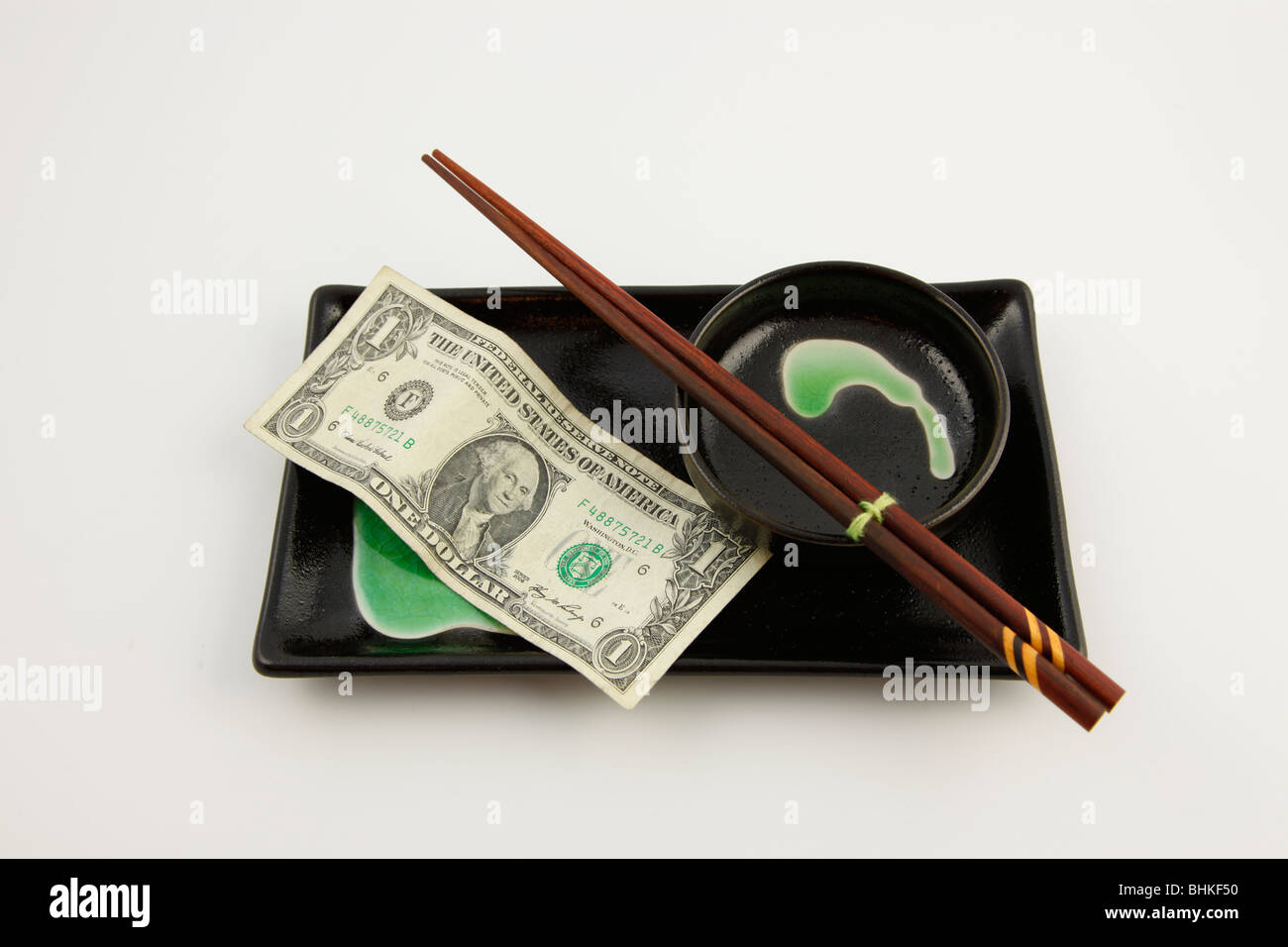 Un dollar des Etats-Unis Bill sur une plaque sushi avec des baguettes Banque D'Images