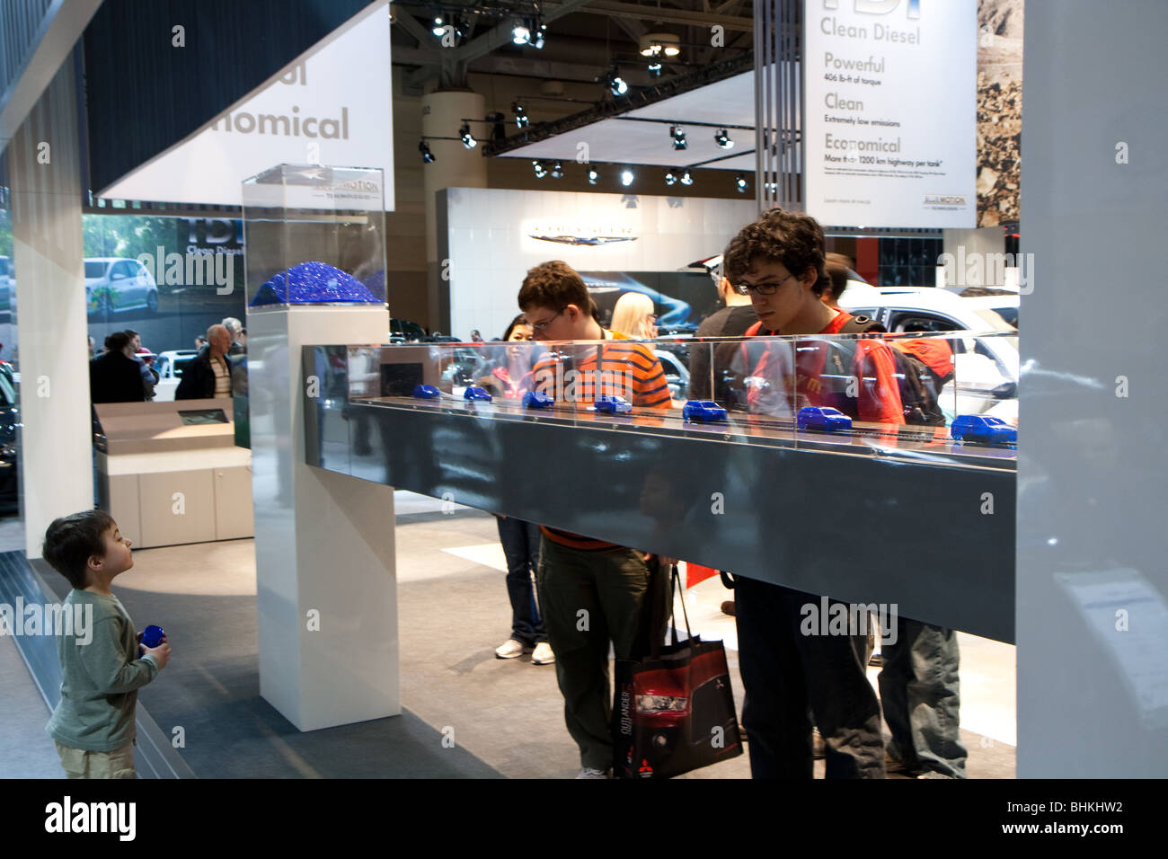 Les enfants regarder les voitures jouet en plastique à être produite dans une chaîne de montage de l'auto stand Volkswagen VW Banque D'Images