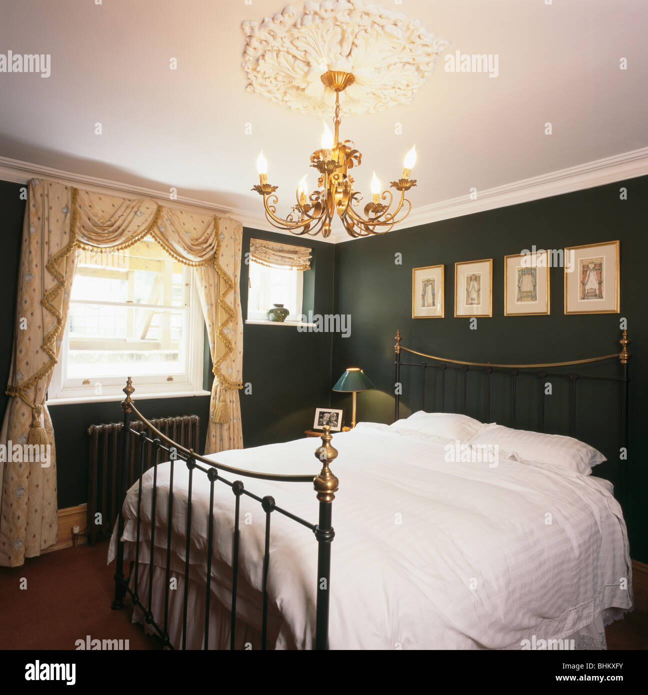 Lustre doré au-dessus de lit en laiton antique en vert et blanc crème  swagged chambre avec les rideaux à la fenêtre Photo Stock - Alamy