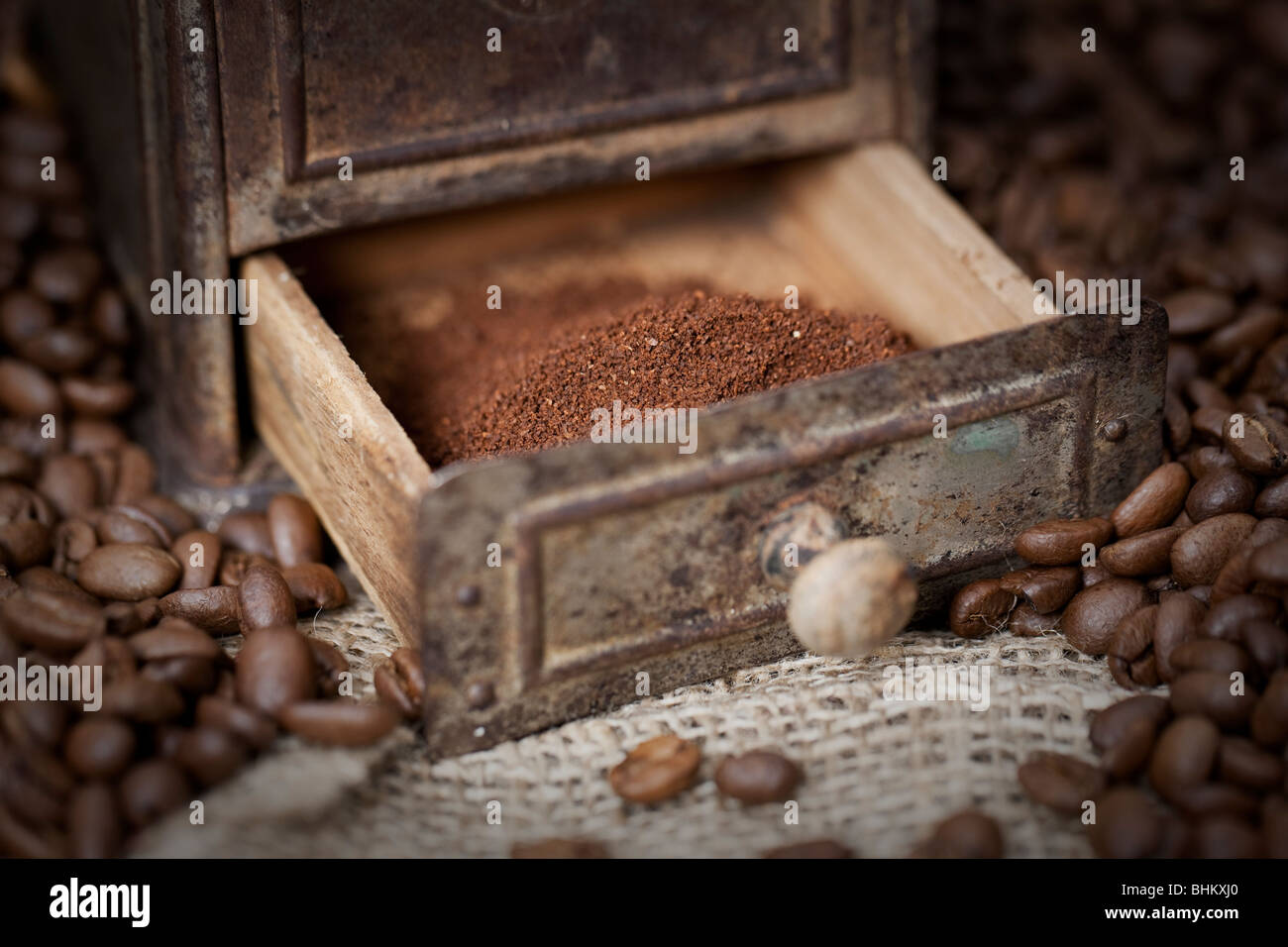 Moulin à café ancien rempli de grains de café - selective focus sur le café moulu Banque D'Images