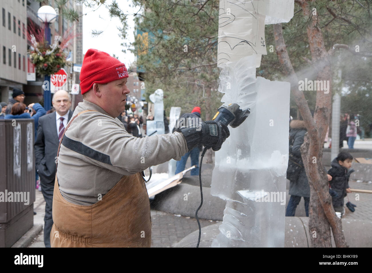 Une sculpture sur glace artiste démontrant sa compétence alors que un spectateur regarde sur Banque D'Images