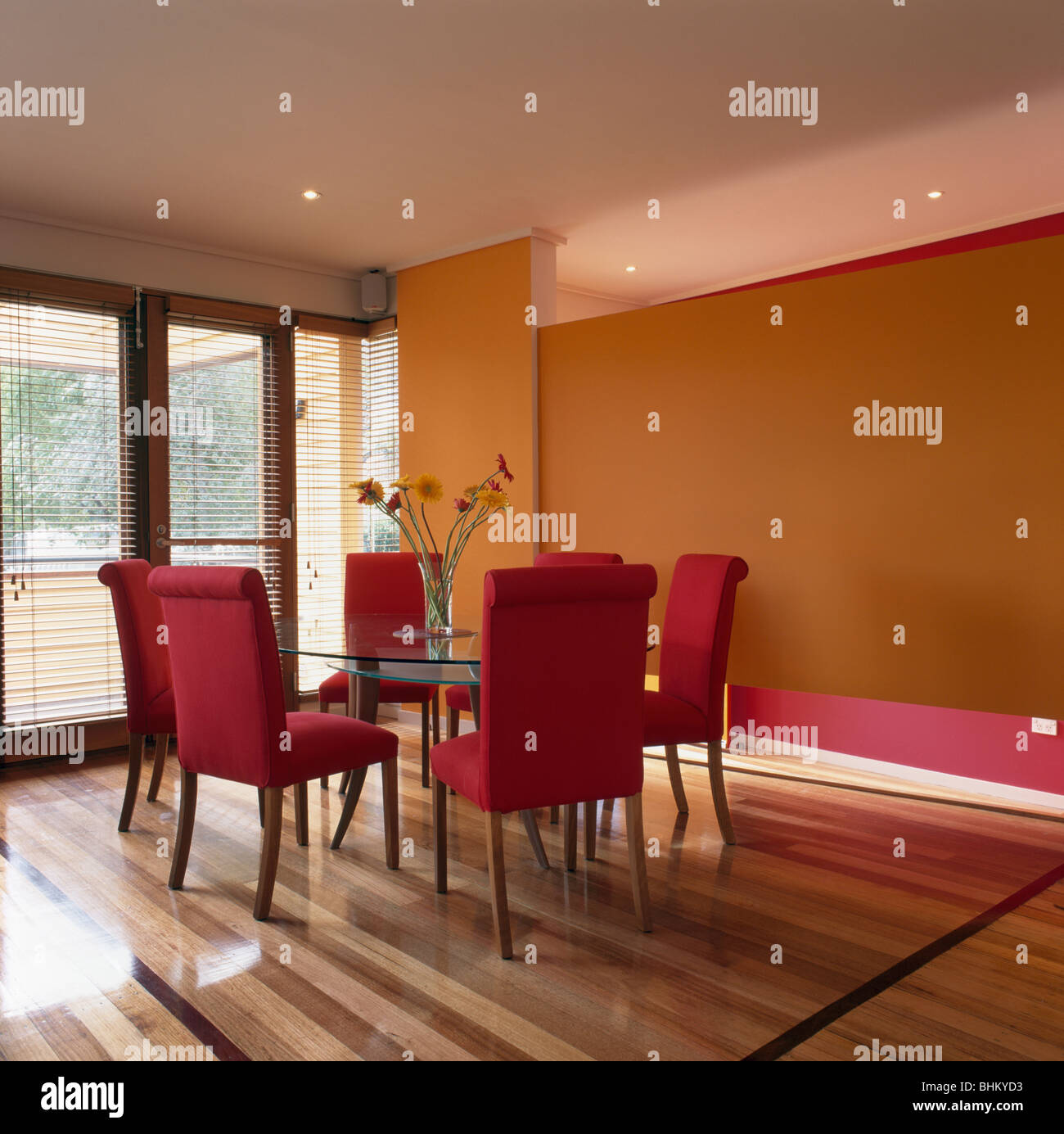Dans de confortables chaises rouge orange moderne salle à manger avec parquet rayé Banque D'Images