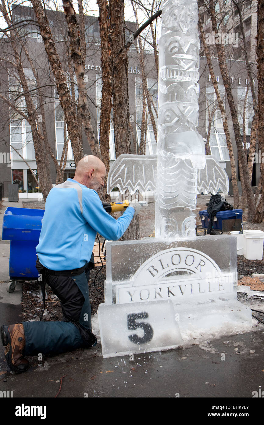 Un artiste de la sculpture sur glace sur une sculpture de glace pour la concurrence. Banque D'Images