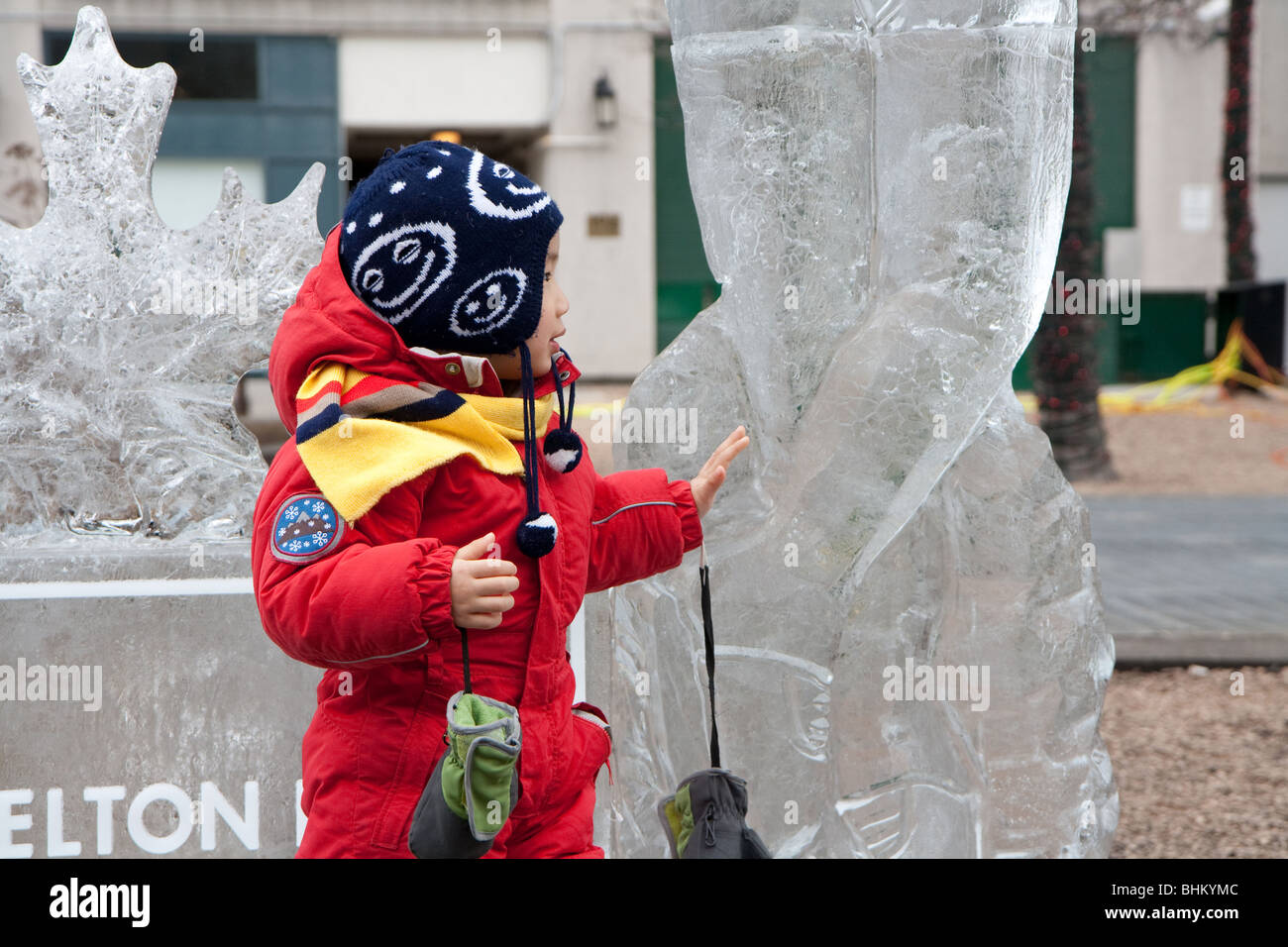 Un garçon asiatique posant pour une photo à côté d'une sculpture de glace Banque D'Images