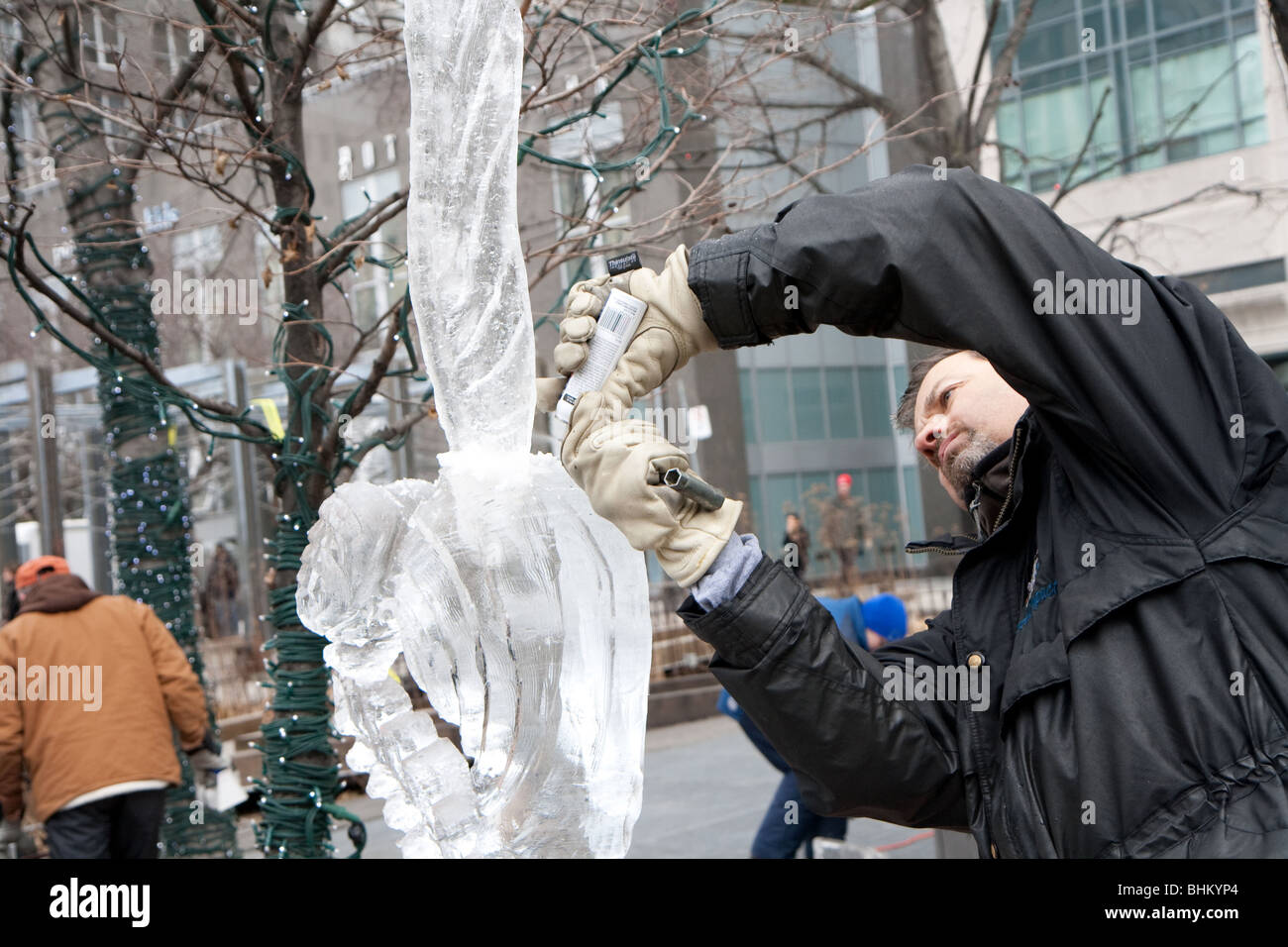 Un homme travaillant sur une sculpture de glace d'une libellule Banque D'Images