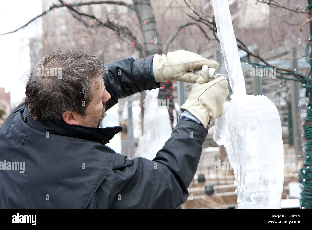 Un homme travaillant sur une sculpture de glace Banque D'Images