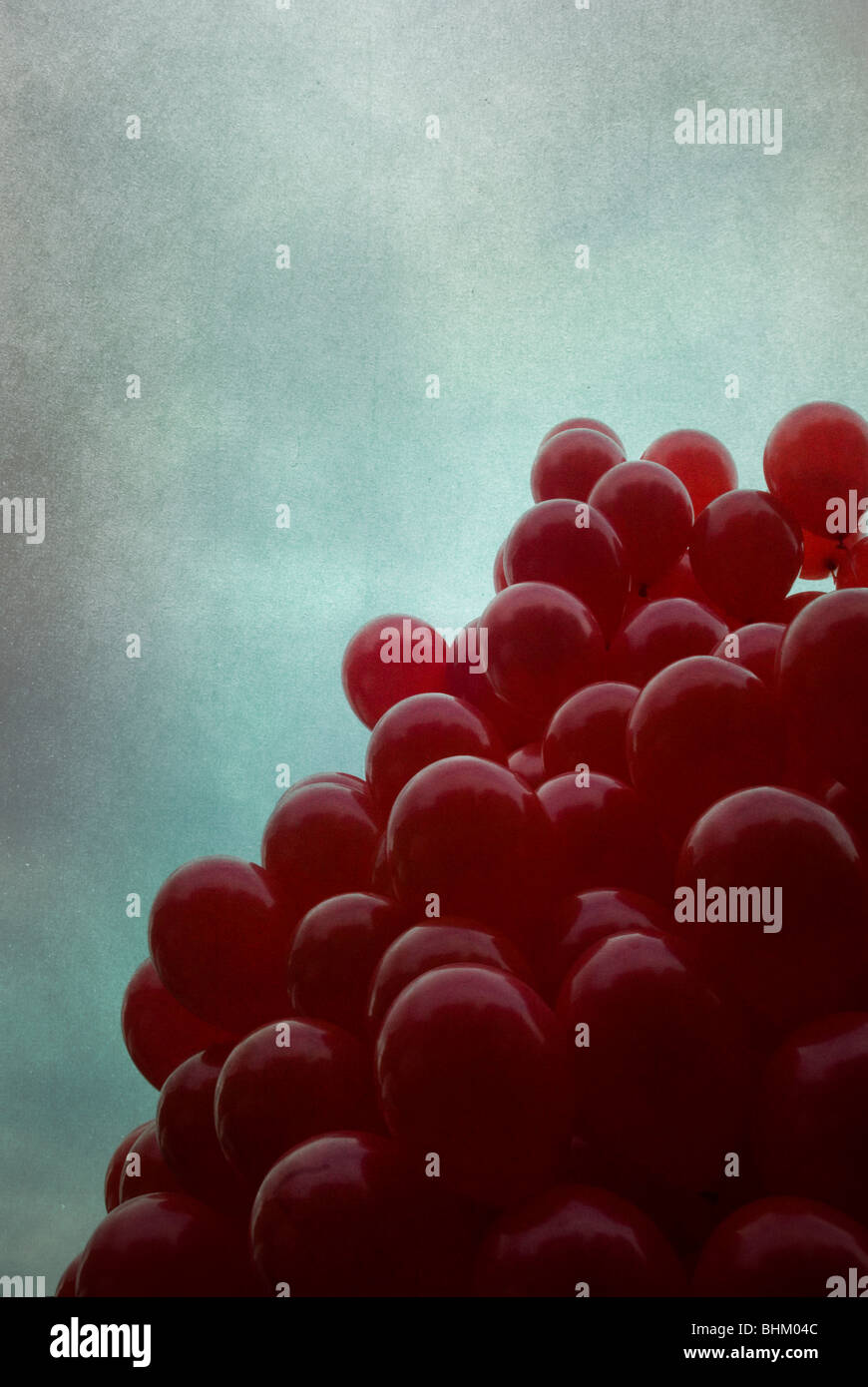 Bouquet de ballons rouges contre un ciel dramatique Banque D'Images