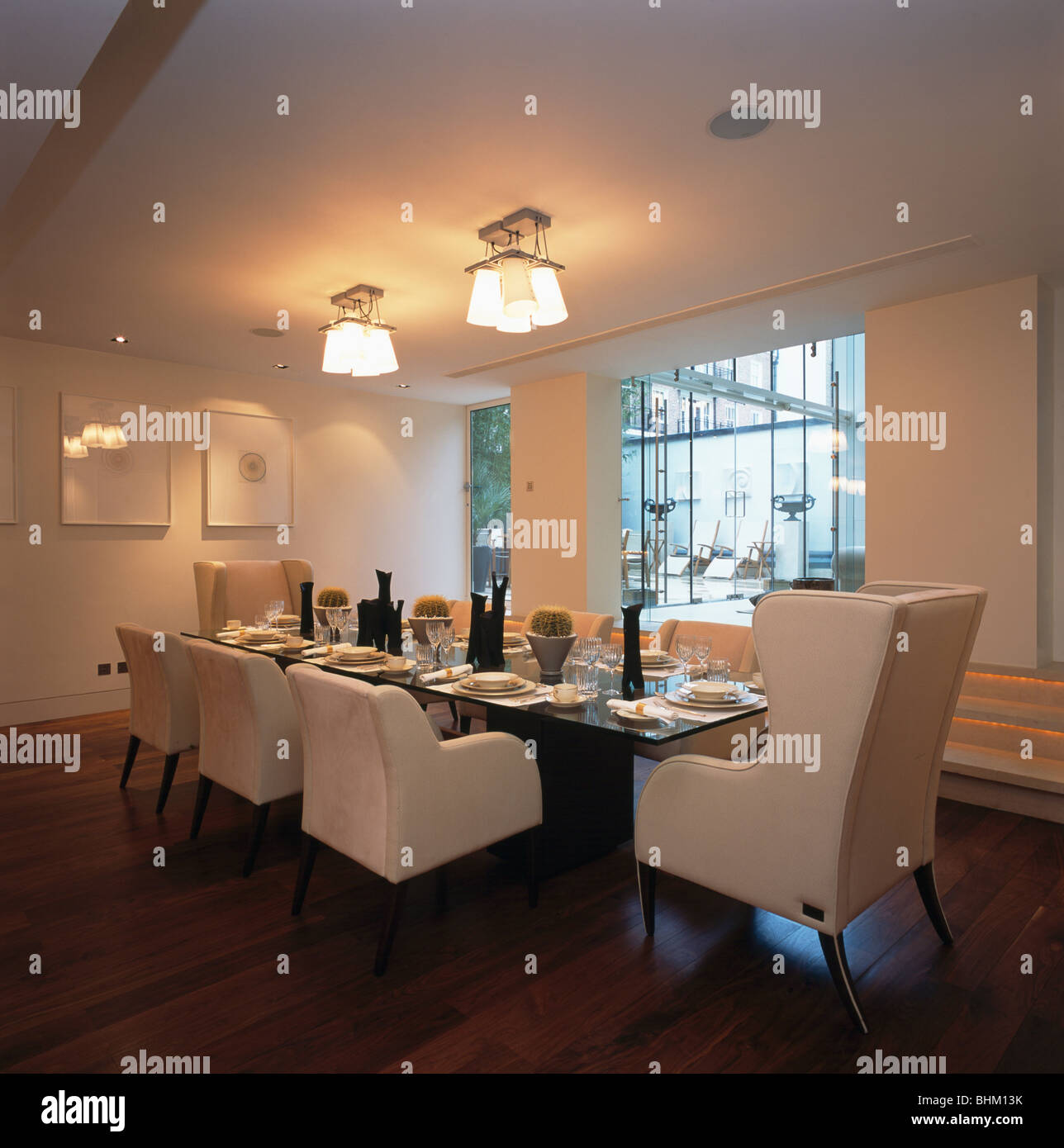 Chaises rembourrées de crème à table en blanc moderne salle à manger avec plafond lumineux éclairé Banque D'Images