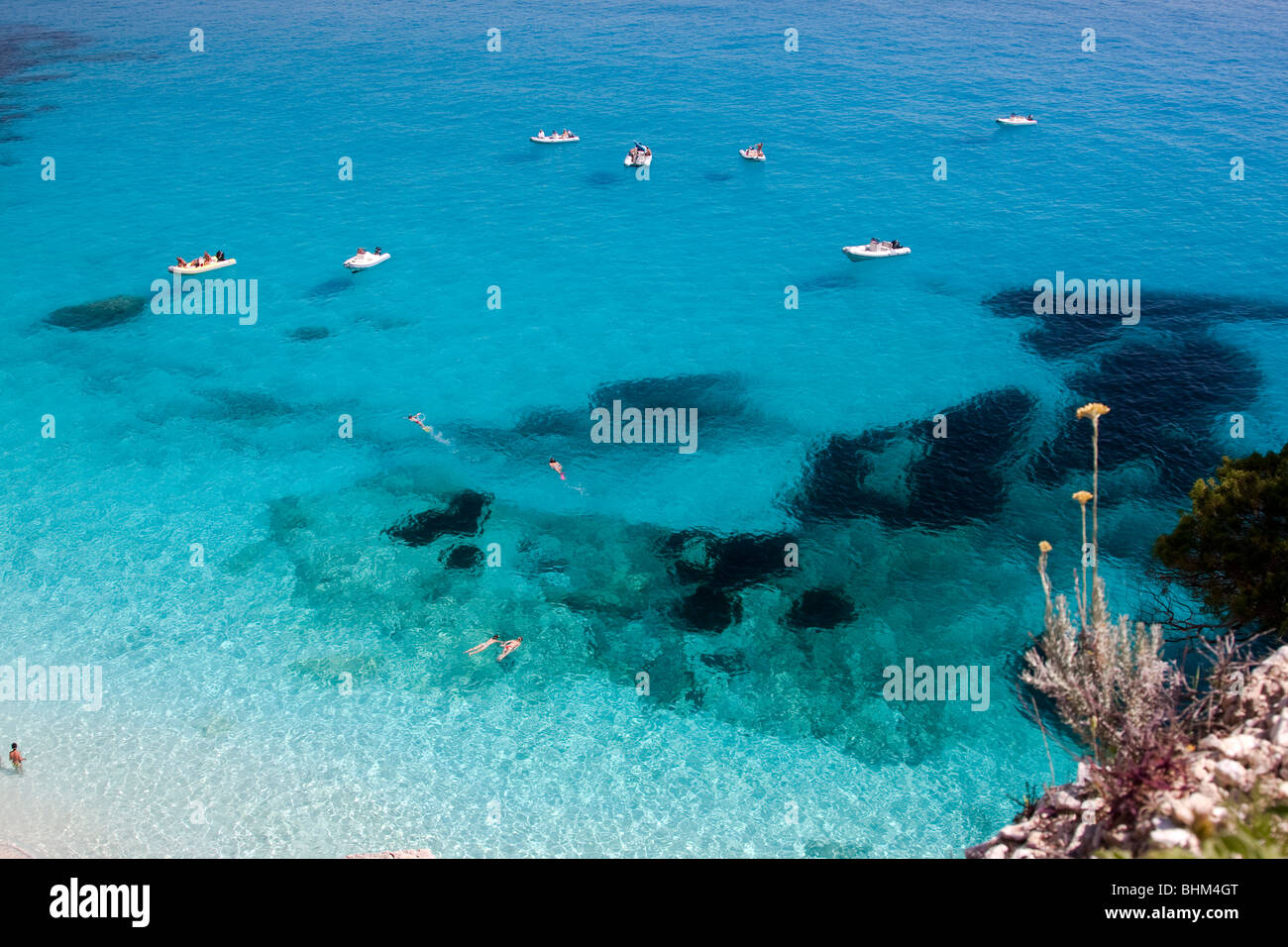 Bateaux dans Cala Goloritze Bay Beach, l'île de Sardaigne en Italie. Eau bleu clair dans la baie de Cala Goloritze, Mer Méditerranée. Banque D'Images