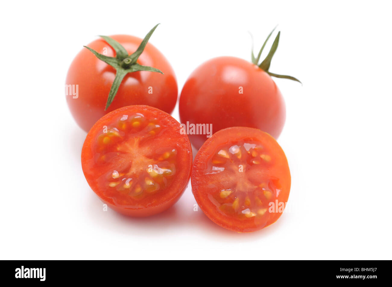 Tomates cerises entières ou coupées en tranches Banque D'Images