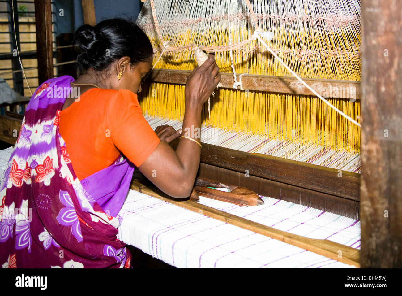 Femme travaillant dans un métier à tisser dans une usine de tissage, Madurai, Tamil Nadu, Inde Banque D'Images