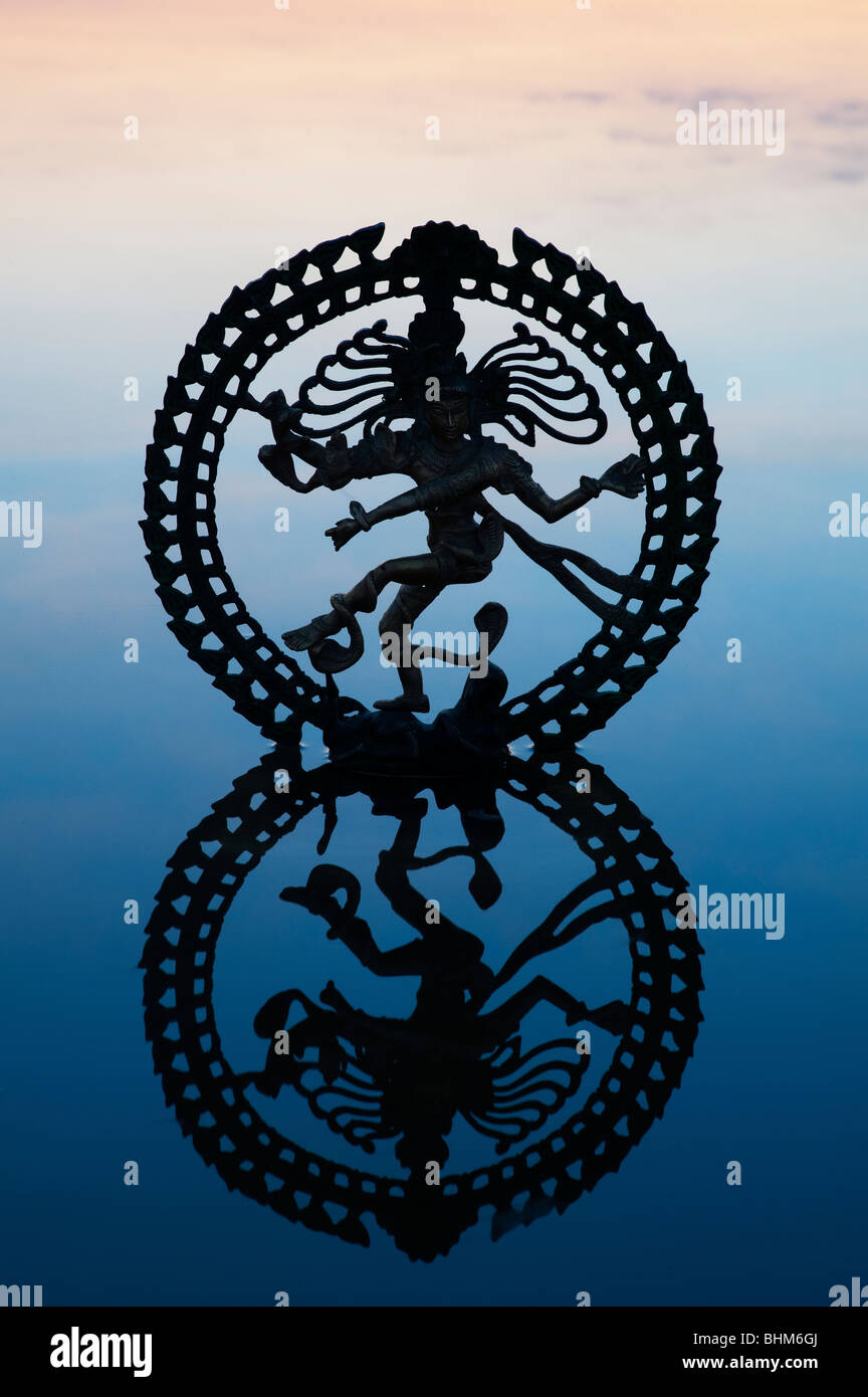 Statue du dieu Shiva danse Nataraja, silhouette, à l'aube se reflétant dans l'eau en Inde Banque D'Images