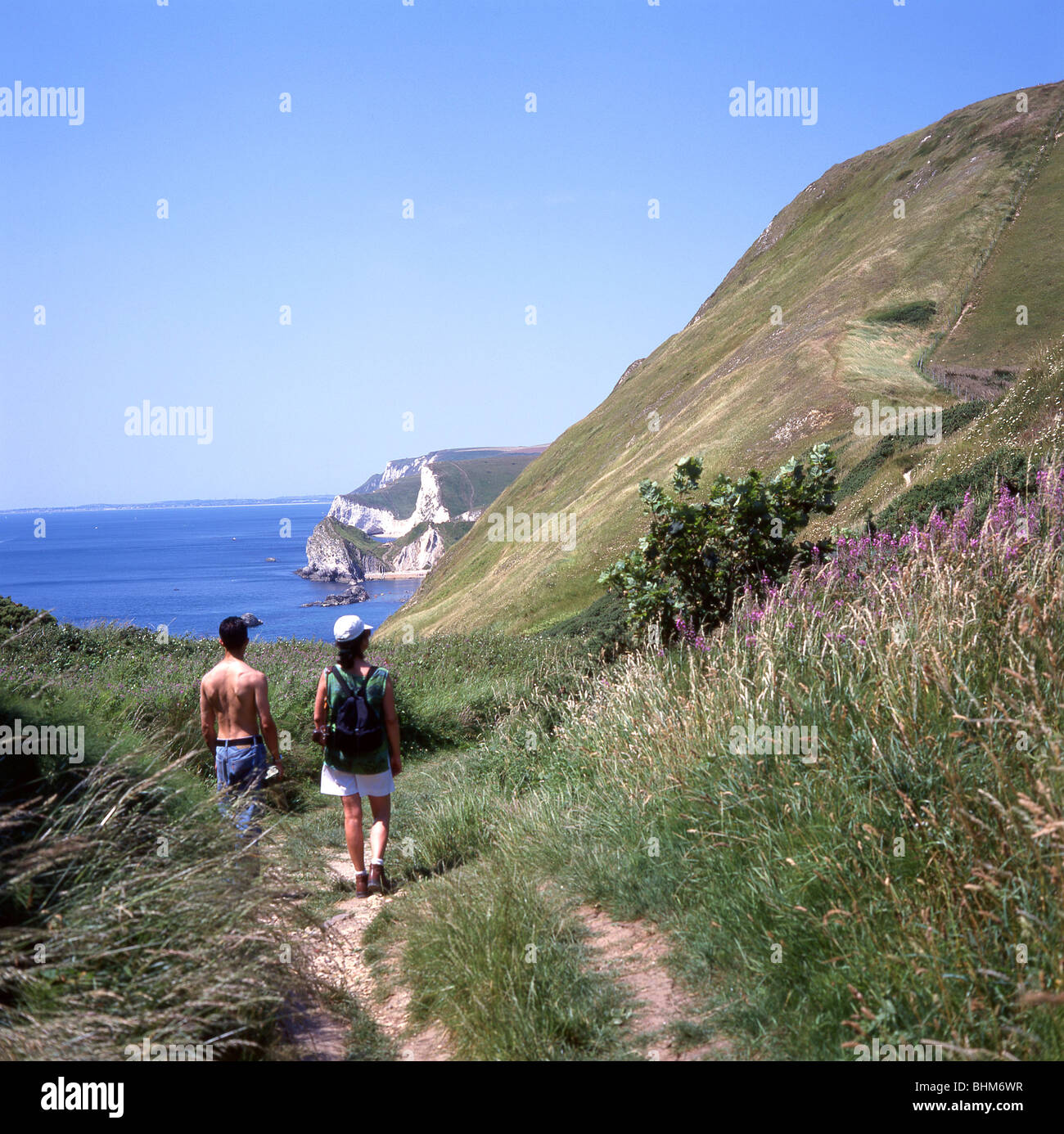 Couple en train de marcher sur le chemin côtier, Man O'War Cove, Dorset, Angleterre, Royaume-Uni Banque D'Images