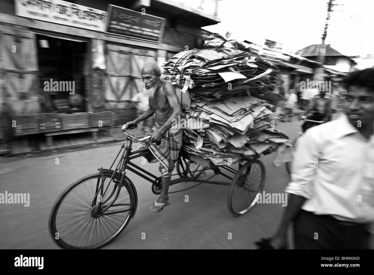 Un cycliste à Barisal Bangladesh transporte pour recyclage de carton sur son pousse-pousse. Banque D'Images