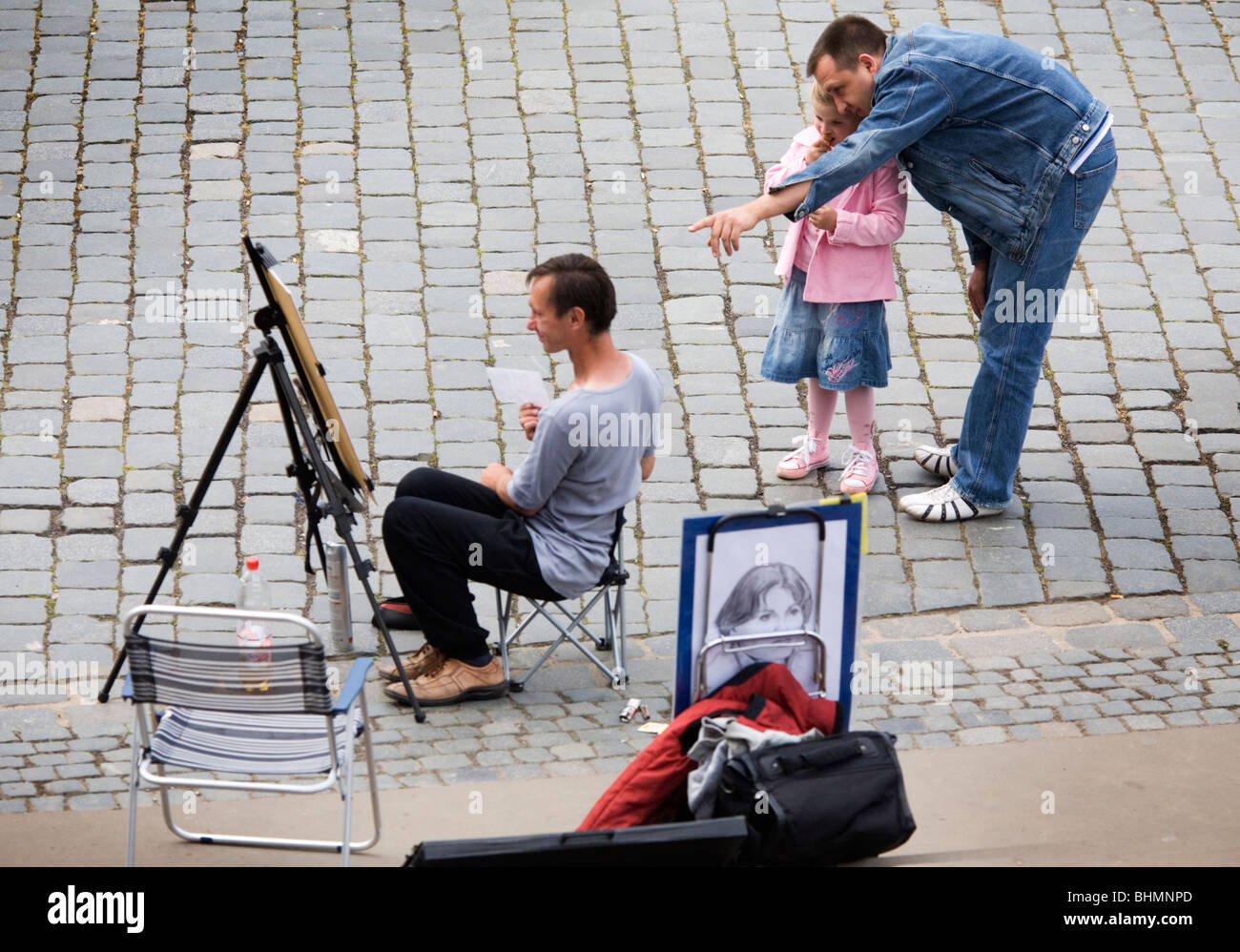 Le père et sa fille qui envisagent le travail d'un artiste de rue, dans une peinture de chevalet de peinture, Dresden, Allemagne Banque D'Images