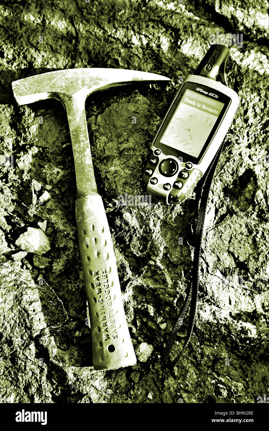 L'exploration minière ; géologues rock marteau et l'unité GPS sur fond de roche riche en minéraux Banque D'Images