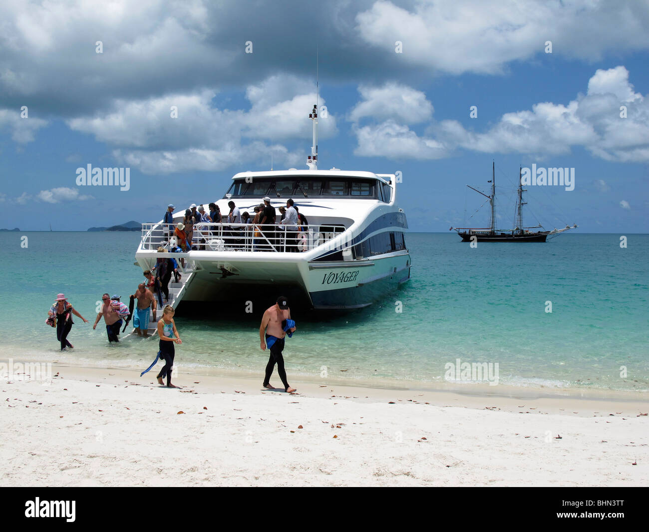 Les touristes débarquent du catamaran 'Voyager' sur une barrière de corail island dans les Whitsundays Banque D'Images