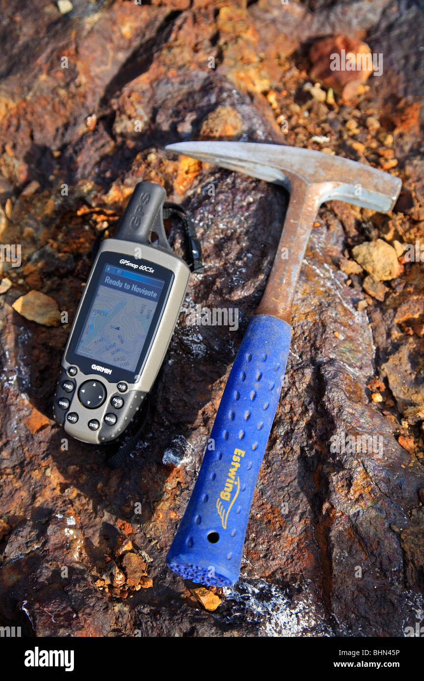 L'exploration minière ; géologues rock marteau et l'unité GPS sur fond de roche riche en minéraux Banque D'Images