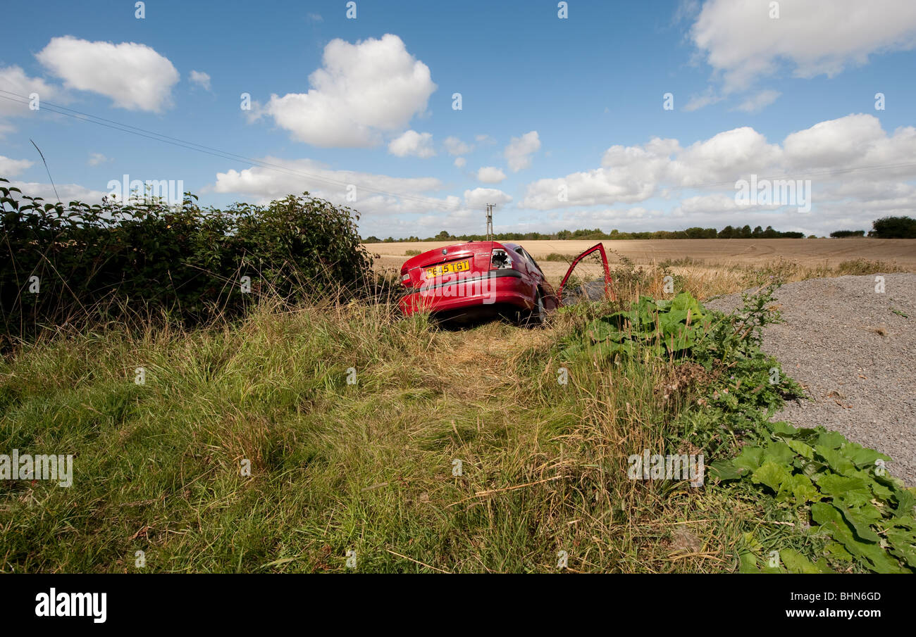 Voiture abandonnée dans les fossés sous-évaluées et délibérément endommagé. Banque D'Images