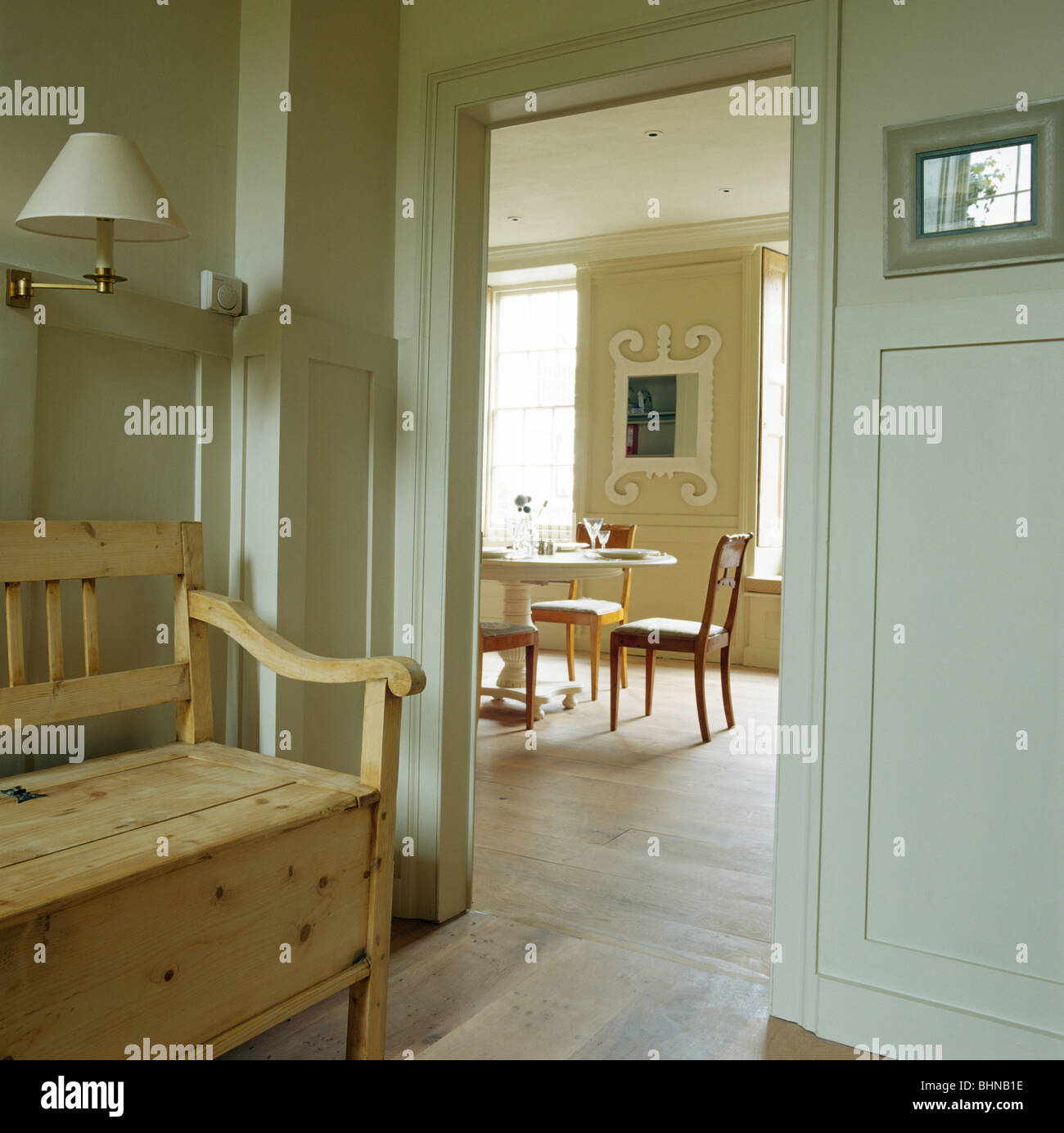 Style Gustavien gris pâle hall peint en peinture Farrow +Ball avec meubles anciens en s'installer à côté de porte ouverte à la salle à manger Banque D'Images