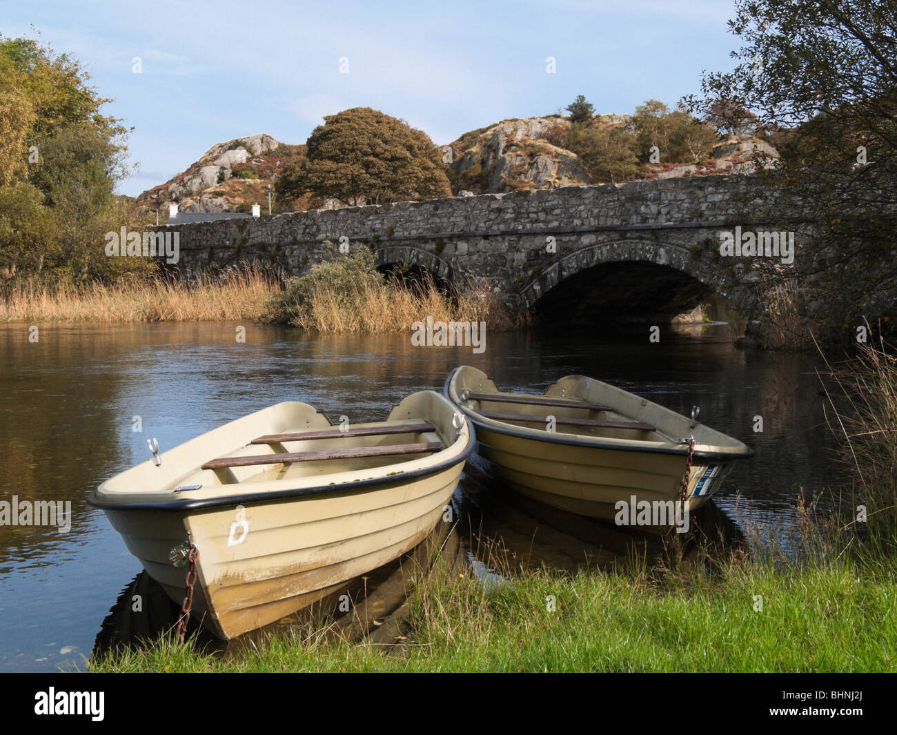 Brynrefail, Gwynedd, au nord du Pays de Galles, Royaume-Uni, Europe. Bateaux amarrés par Rhythallt d'Afon, près de Vieux pont de pierre dans la région de Snowdonia, Banque D'Images