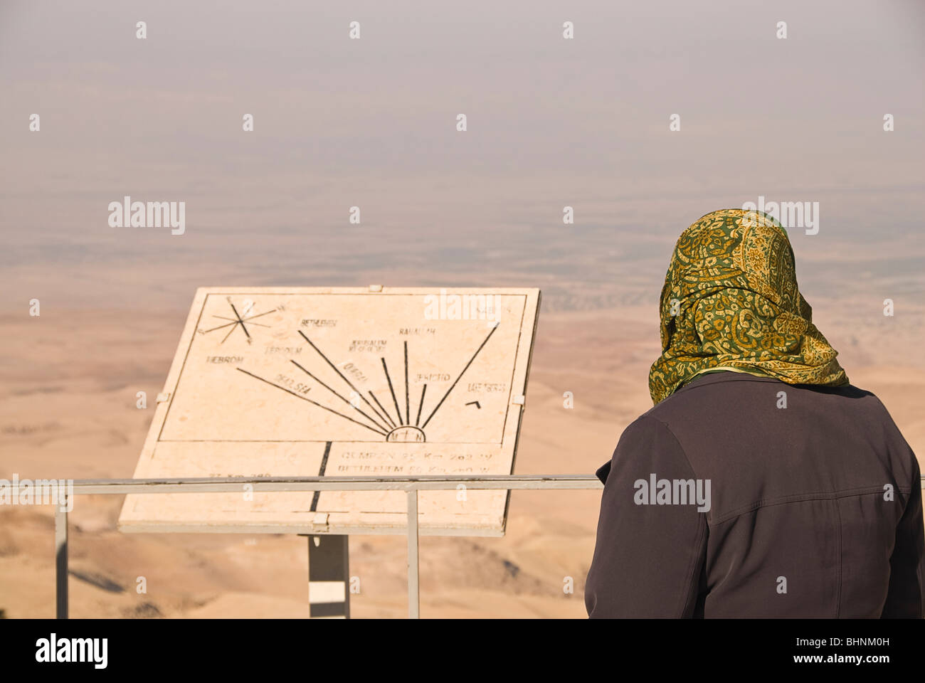 Femme à la recherche d'un panneau pointant vers la terre promise au mont Nebo, Jordanie, Asie. Banque D'Images