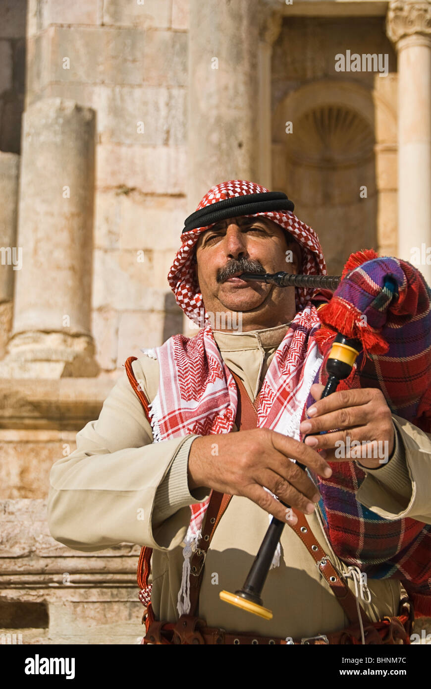 Man blowing le pipa à les vestiges romains de Jerash, Jordanie, Asie. Banque D'Images